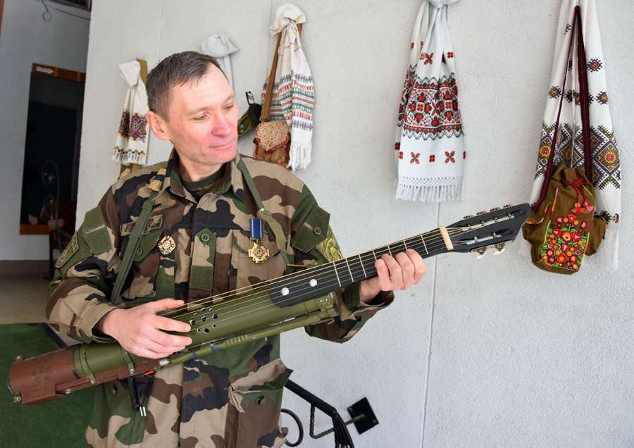 Павло Ротар налаштовує гітару з частин гранатомета. Фото автора